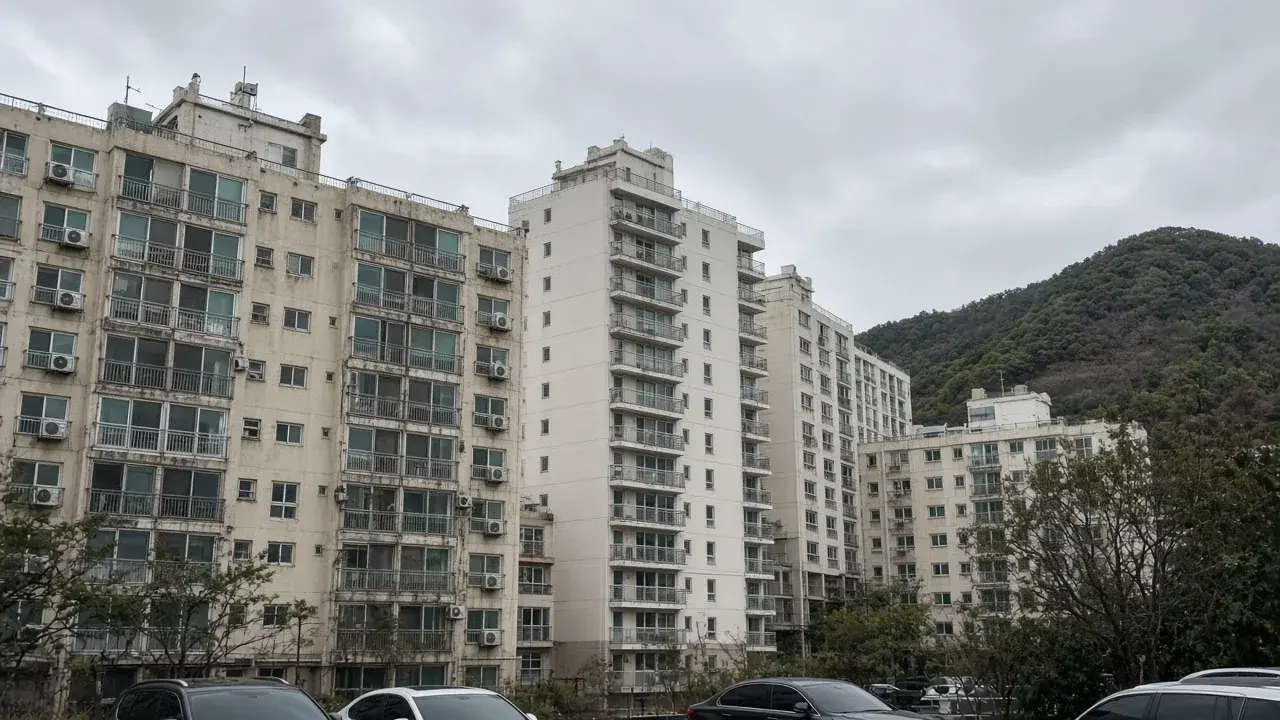 흐린 날 산 아래로 늘어선 아파트 단지.
