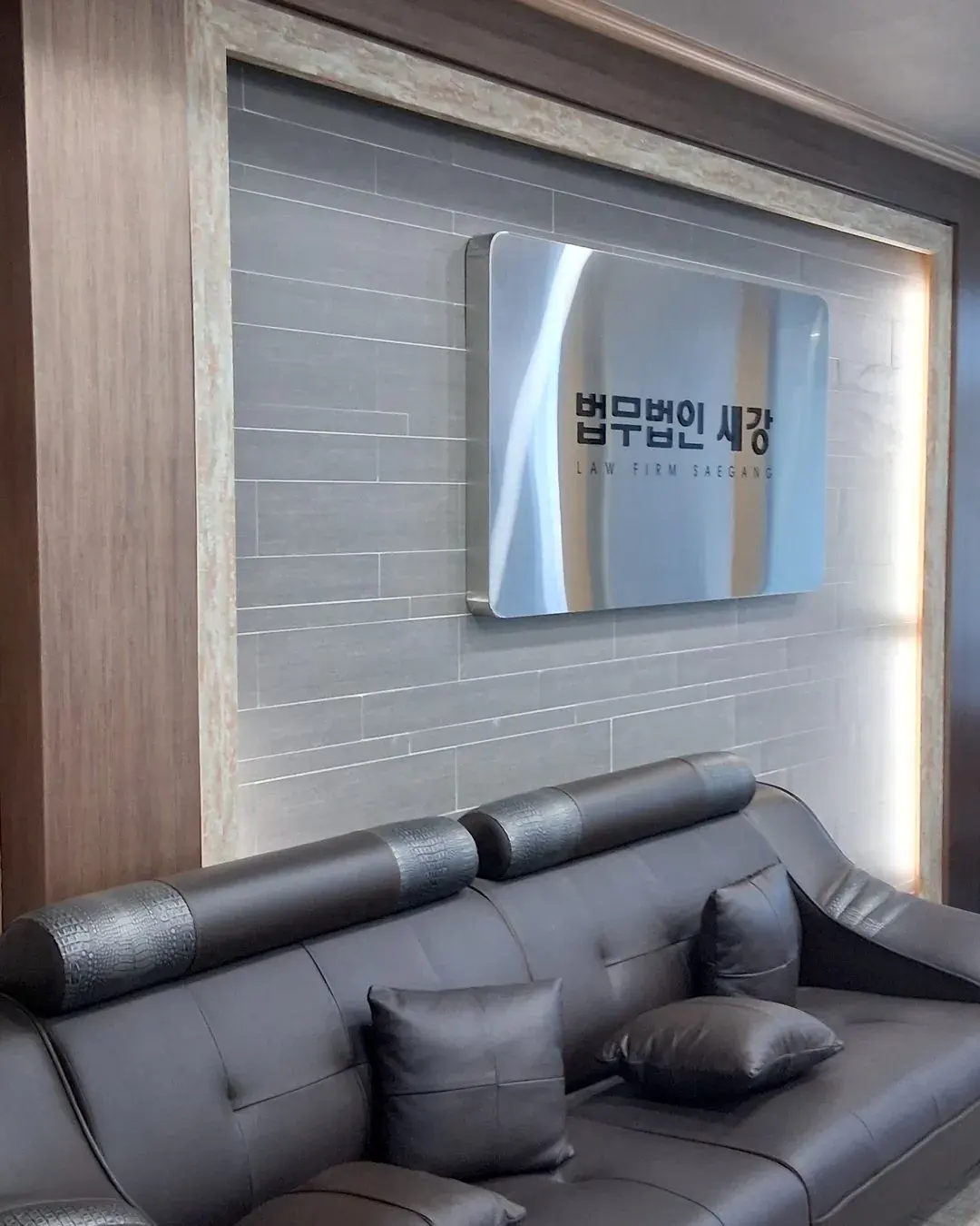 법무법인 새강 간판 아래 소파가 놓인 사무소 대기 공간