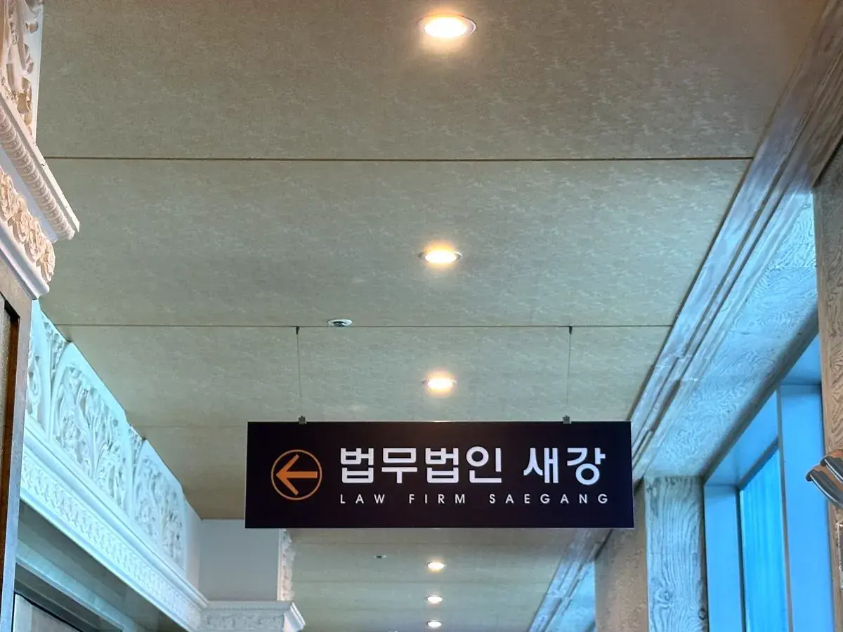 천장에 매달린 법무법인 새강 방향 안내판이 보이는 복도